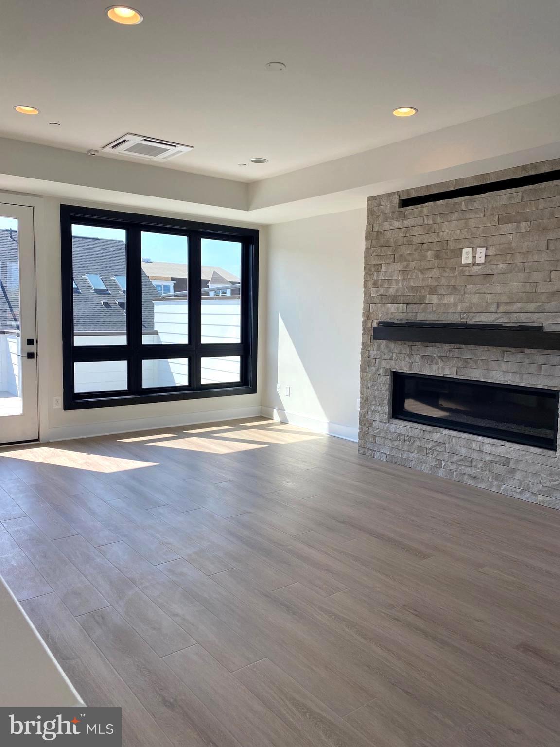 14944 Dispatch Street, Unit 2 Rockville, MD 20850 - Photo 28 of 36 a view of an empty room with wooden floor and a window