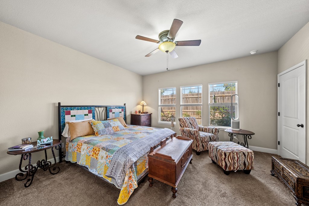 116 Jasper Lane North Kerrville, TX 78028 - Photo 11 of 27 a bedroom with a bed and a chandelier