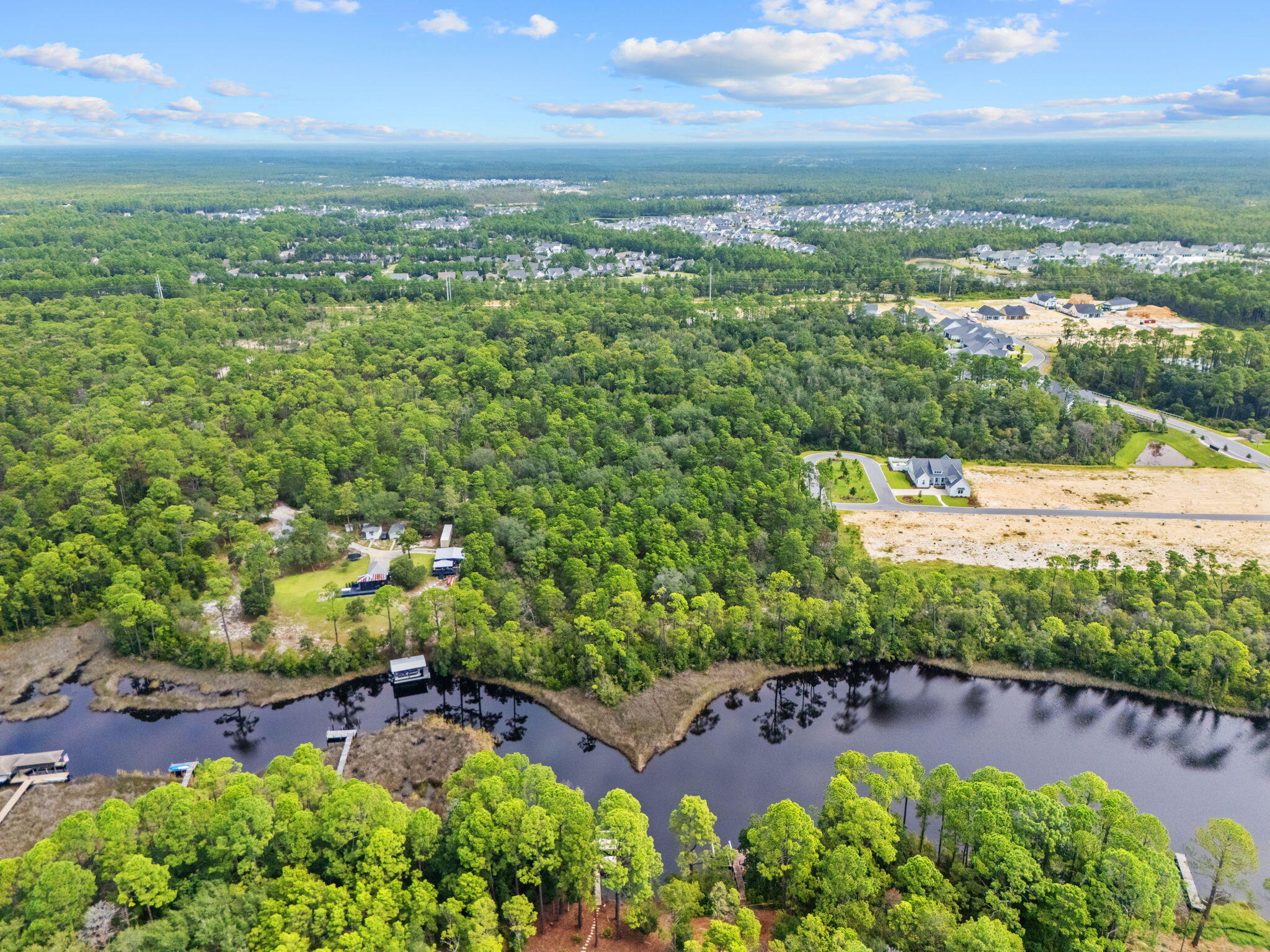 an aerial view of residential houses with outdoor space and trees