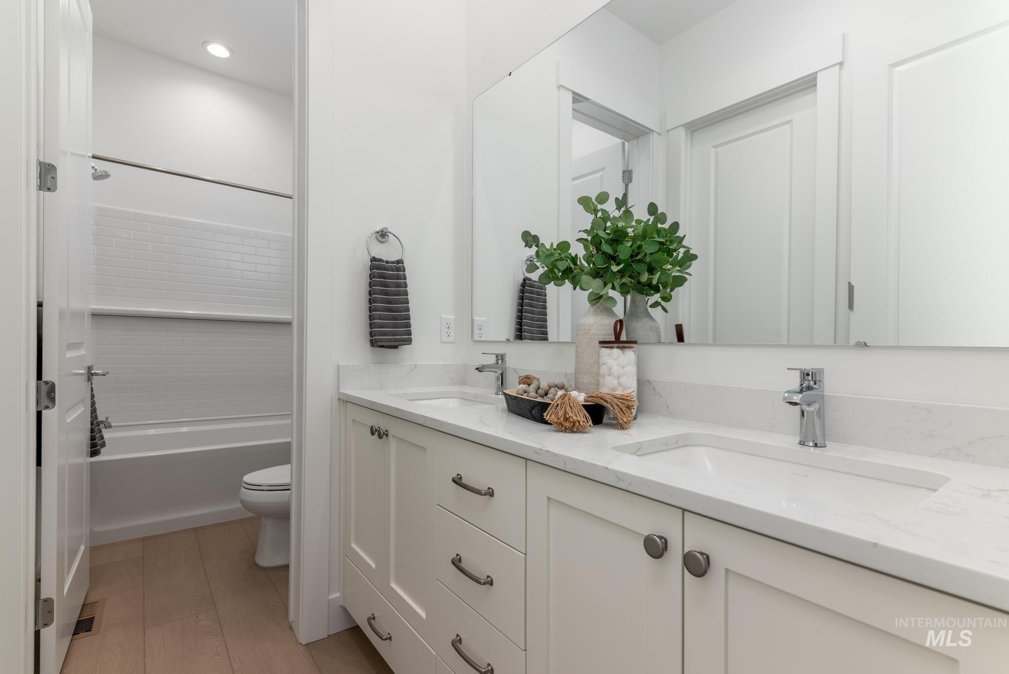 8558 South Silver Smog Way Meridian, ID 83642 - Photo 26 of 41 Double vanity with integrated sinks and chrome fixtures, featuring a large mirror and light-toned cabinetry