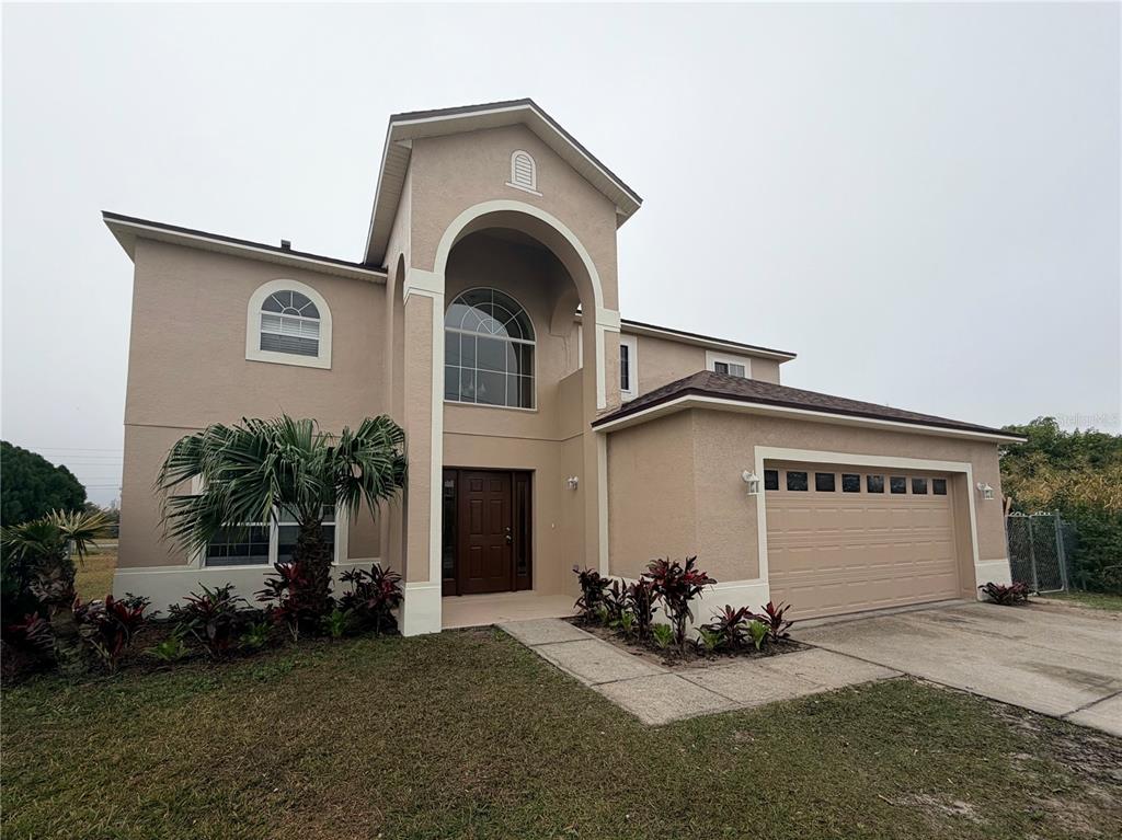 413 Britten Drive Kissimmee, FL 34758 - Photo 1 of 20 a front view of a house with a garden and plants