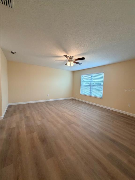 413 Britten Drive Kissimmee, FL 34758 - Photo 6 of 20 wooden floor in an empty room with a window