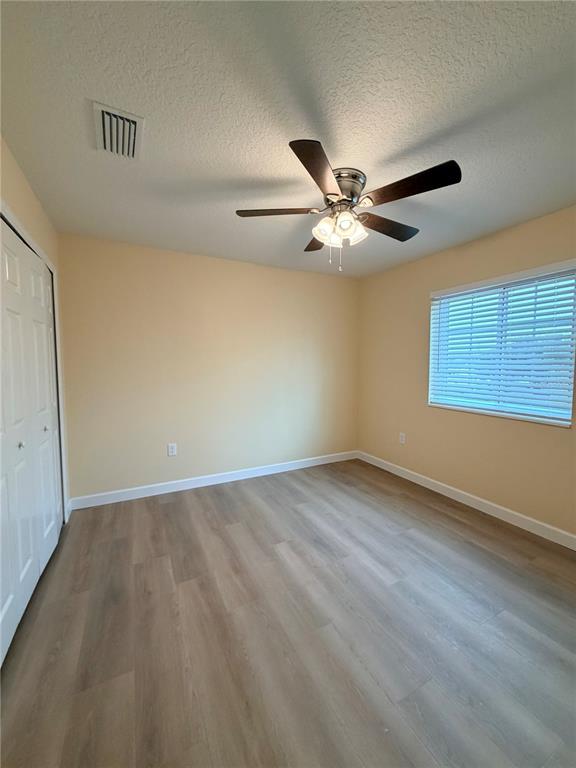 413 Britten Drive Kissimmee, FL 34758 - Photo 10 of 20 wooden floor in an empty room with a window