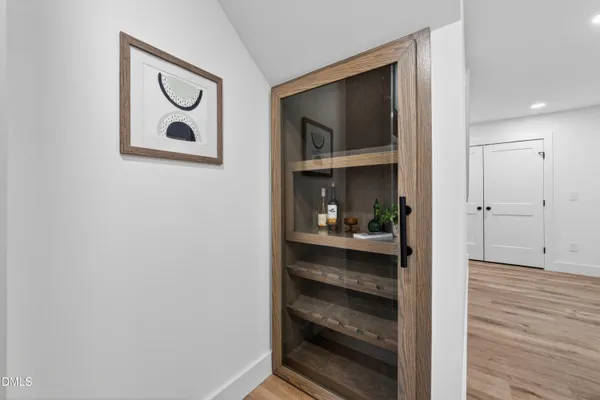 a view of a hallway with wooden floor and closet