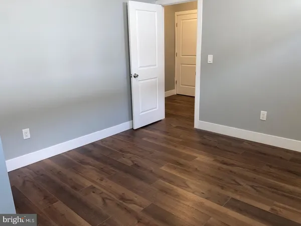 an empty room with wooden floor and entrance