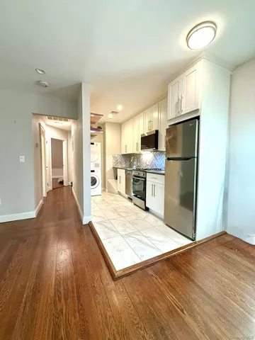 a view of kitchen living room with wooden floor and electronic appliances