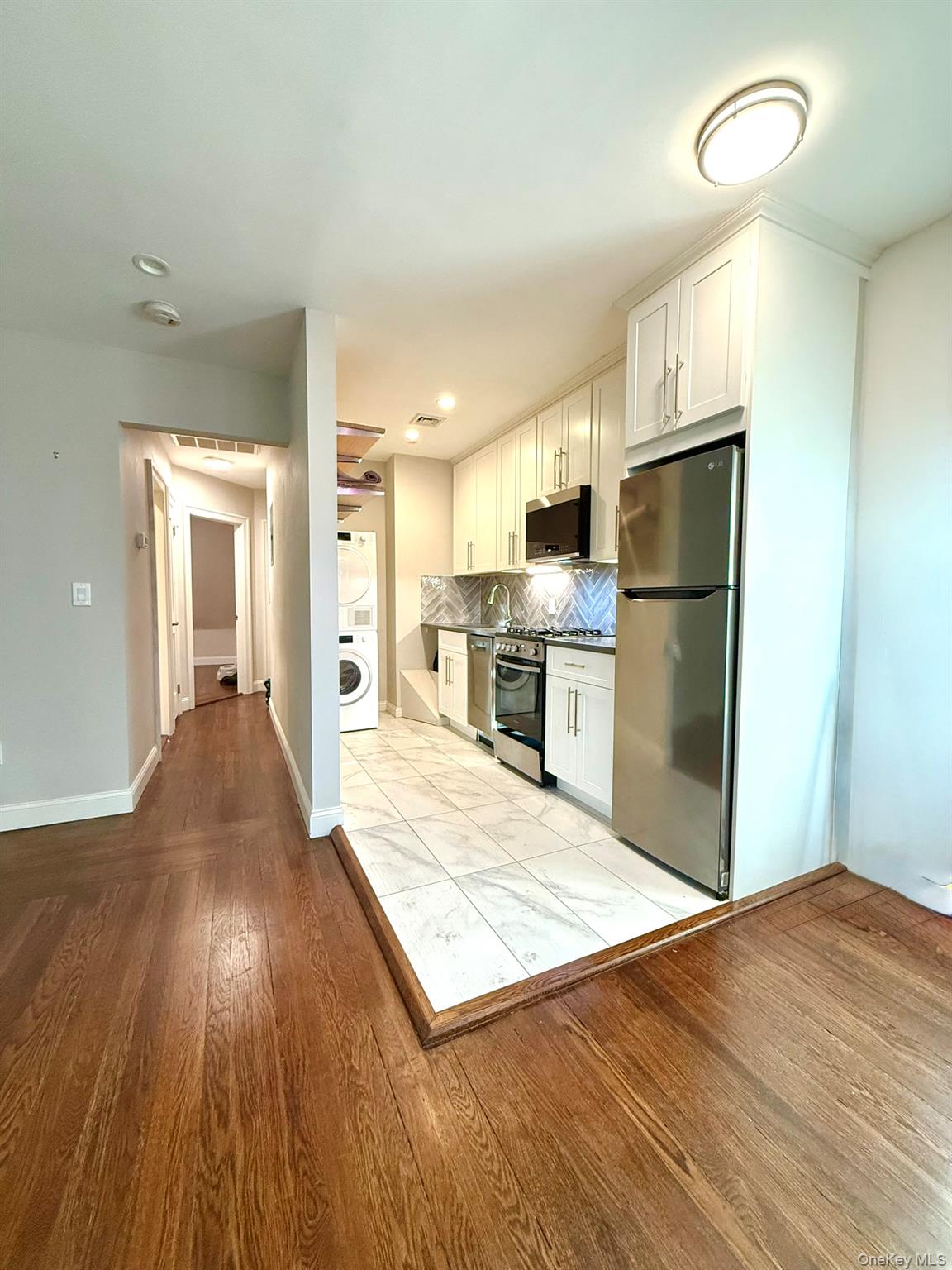 a view of kitchen living room with wooden floor and electronic appliances