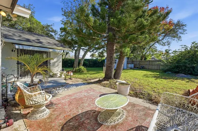 a view of house with a yard and potted plants