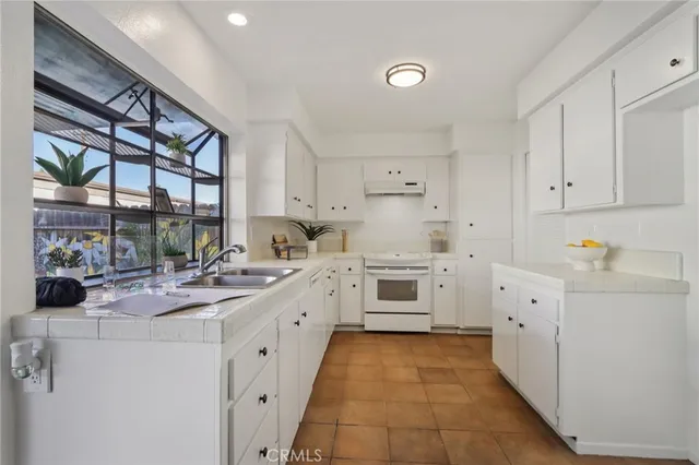 a kitchen with white cabinets and white appliances