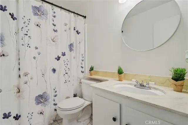 a bathroom with a granite countertop sink a toilet and a mirror