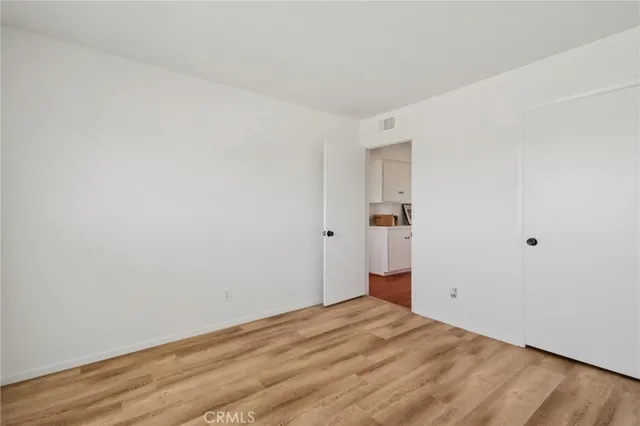 a view of empty room with wooden floor and window