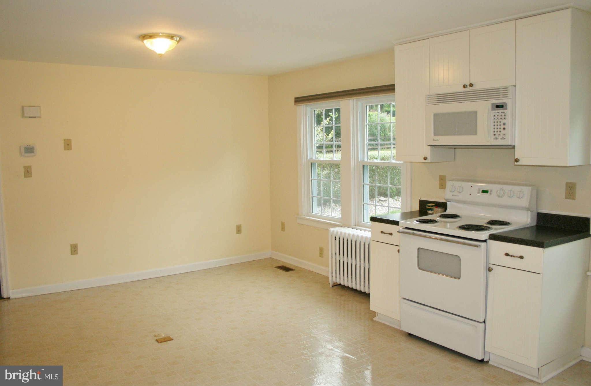 10529 Old Court Road Woodstock, MD 21163 - Photo 13 of 26 a kitchen with white cabinets and white appliances