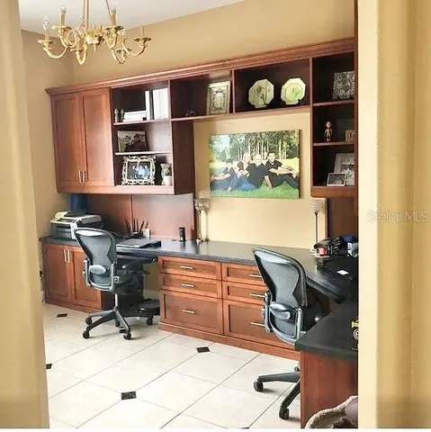 a view of a workspace with furniture and a window