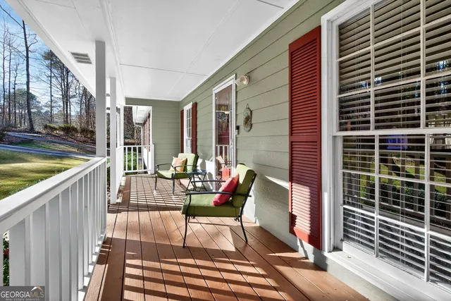 a balcony with chairs and with potted plants