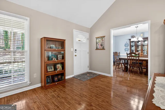 a view of a dining room with furniture a chandelier and wooden floor