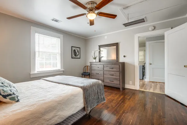 a spacious bedroom with a bed and a dresser