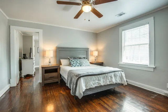 a bedroom with a bed and wooden floor