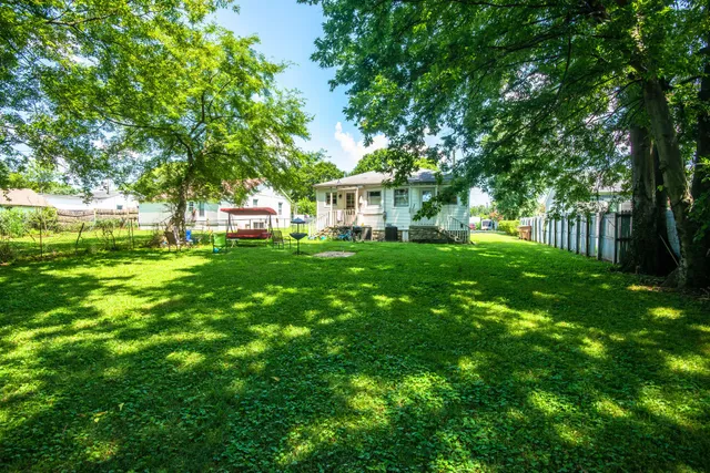 a backyard of a house with table and chairs