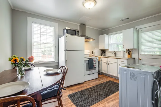 a kitchen with sink a refrigerator and windows