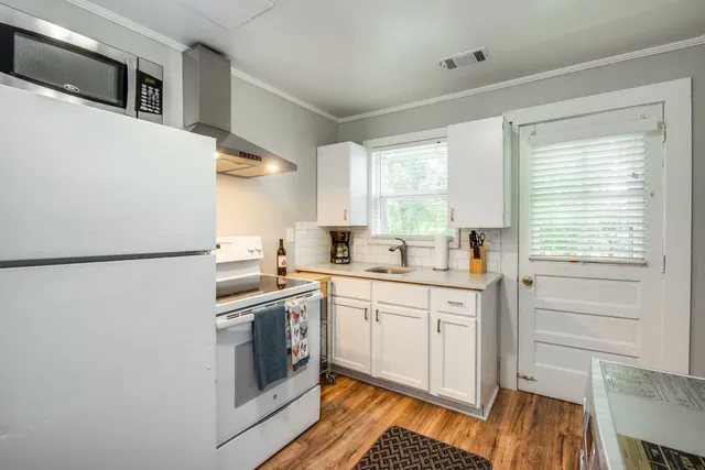 a kitchen with a sink cabinets stainless steel appliances and a window