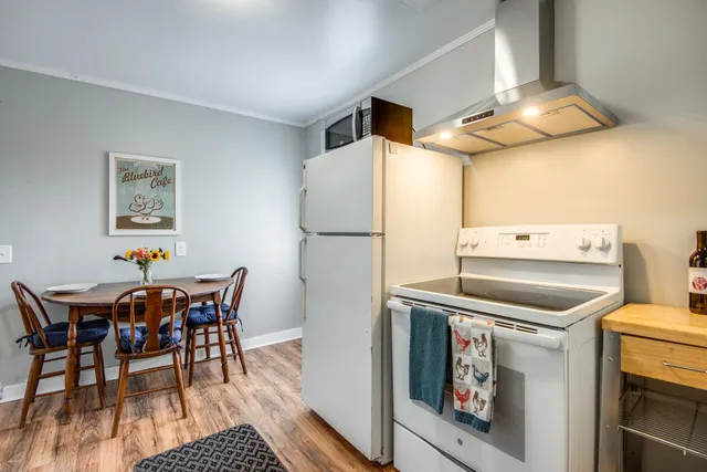 a kitchen with a table chairs and a refrigerator