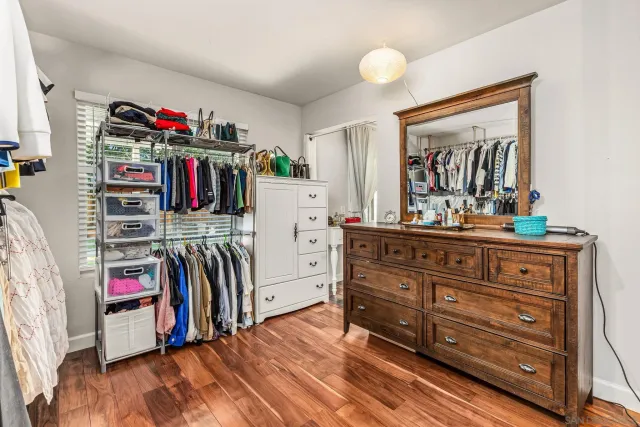 a view of walk in closet with clothes shoes and a mirror