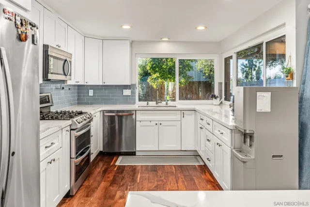 a kitchen with white cabinets and white appliances