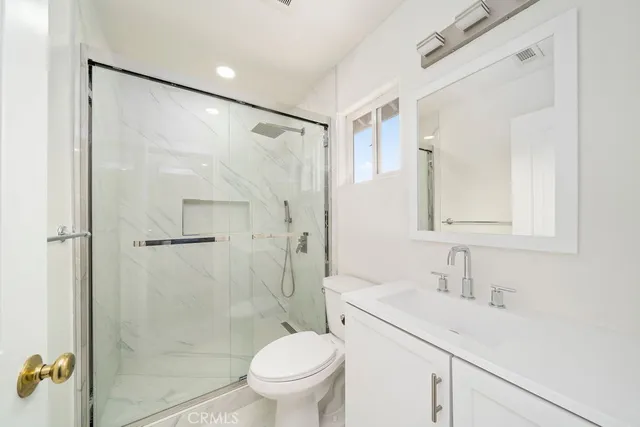 a bathroom with a sink mirror vanity and toilet
