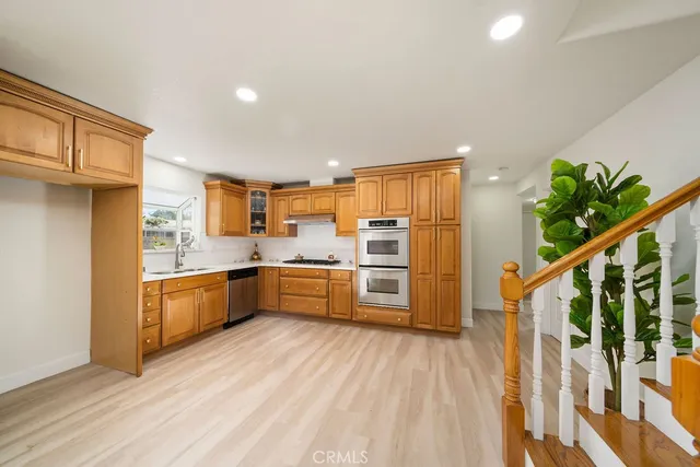 a kitchen with stainless steel appliances kitchen island granite countertop a stove top oven a sink and dishwasher