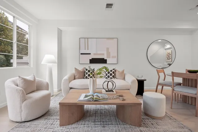 a living room with furniture a window and a potted plant