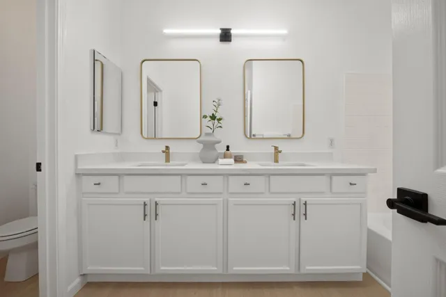 a bathroom with double vanity sink and a mirror