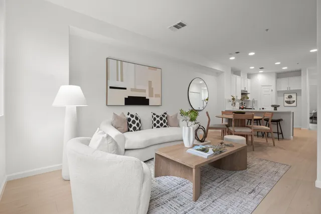 a living room with furniture a rug and white walls