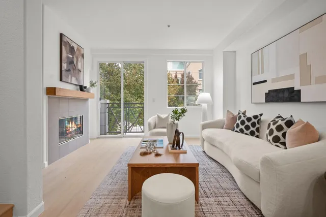a living room with furniture a fireplace and a large window