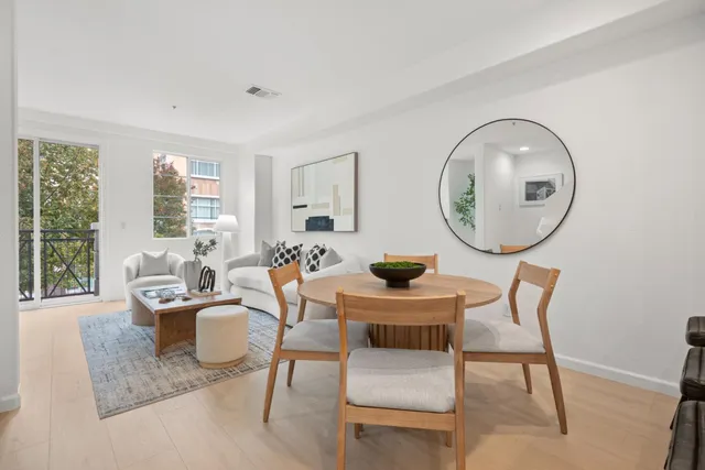 a living room with furniture a mirror and a large window