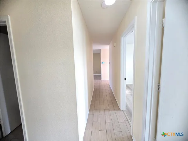 a view of a hallway with wooden floor