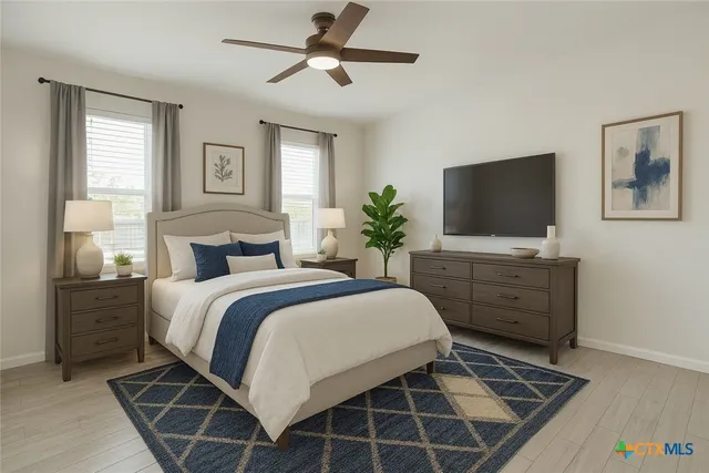 a spacious bedroom with a bed and a flat screen television