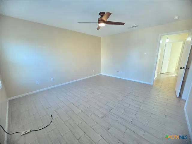 a view of a room with wooden floor and a chandelier