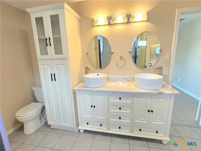 a bathroom with a sink a toilet and mirror