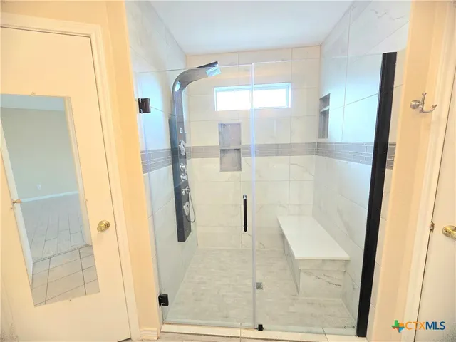 a bathroom with a glass shower door and a glass door