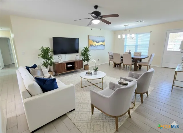 a living room with furniture a flat screen tv and a dining table