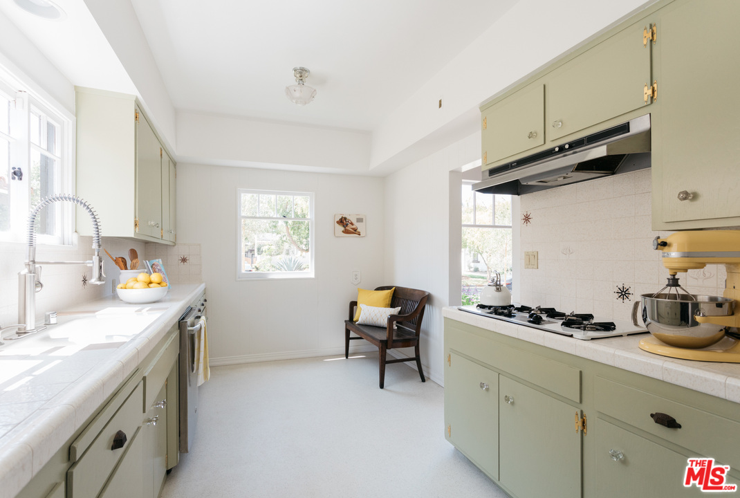 6151 Barrows Drive Los Angeles, CA 90048 - Photo 8 of 25 a kitchen with stainless steel appliances a sink a stove and a refrigerator