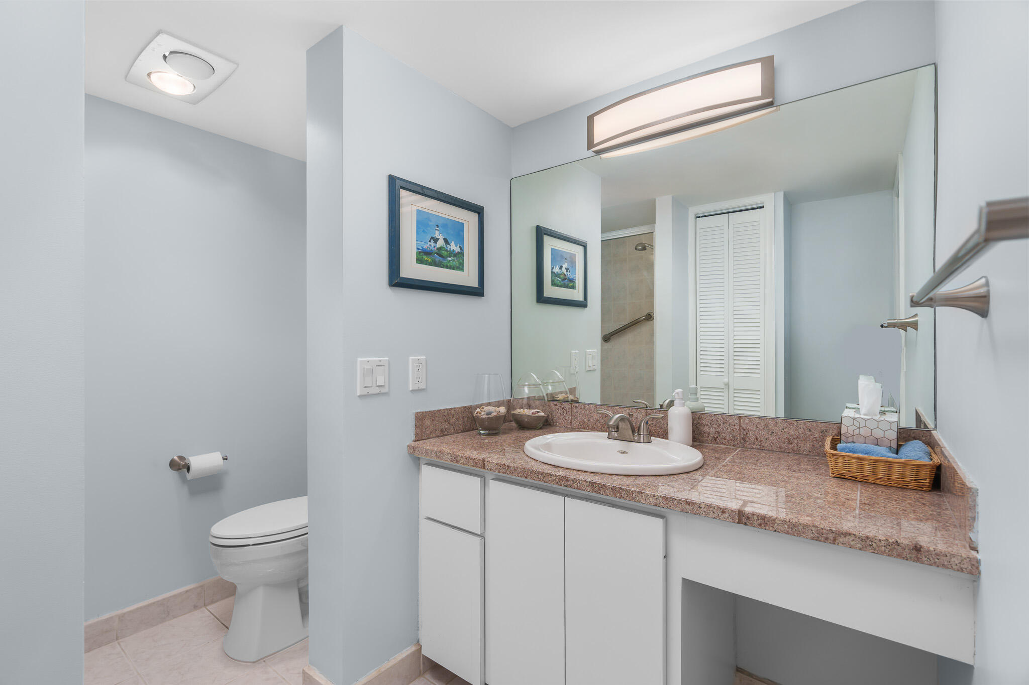 950 Ponce De Leon Road, Unit 207 Boca Raton, FL 33432 - Photo 19 of 36 a bathroom with a granite countertop toilet a sink and a mirror