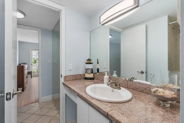 a bathroom with a granite countertop sink and a mirror