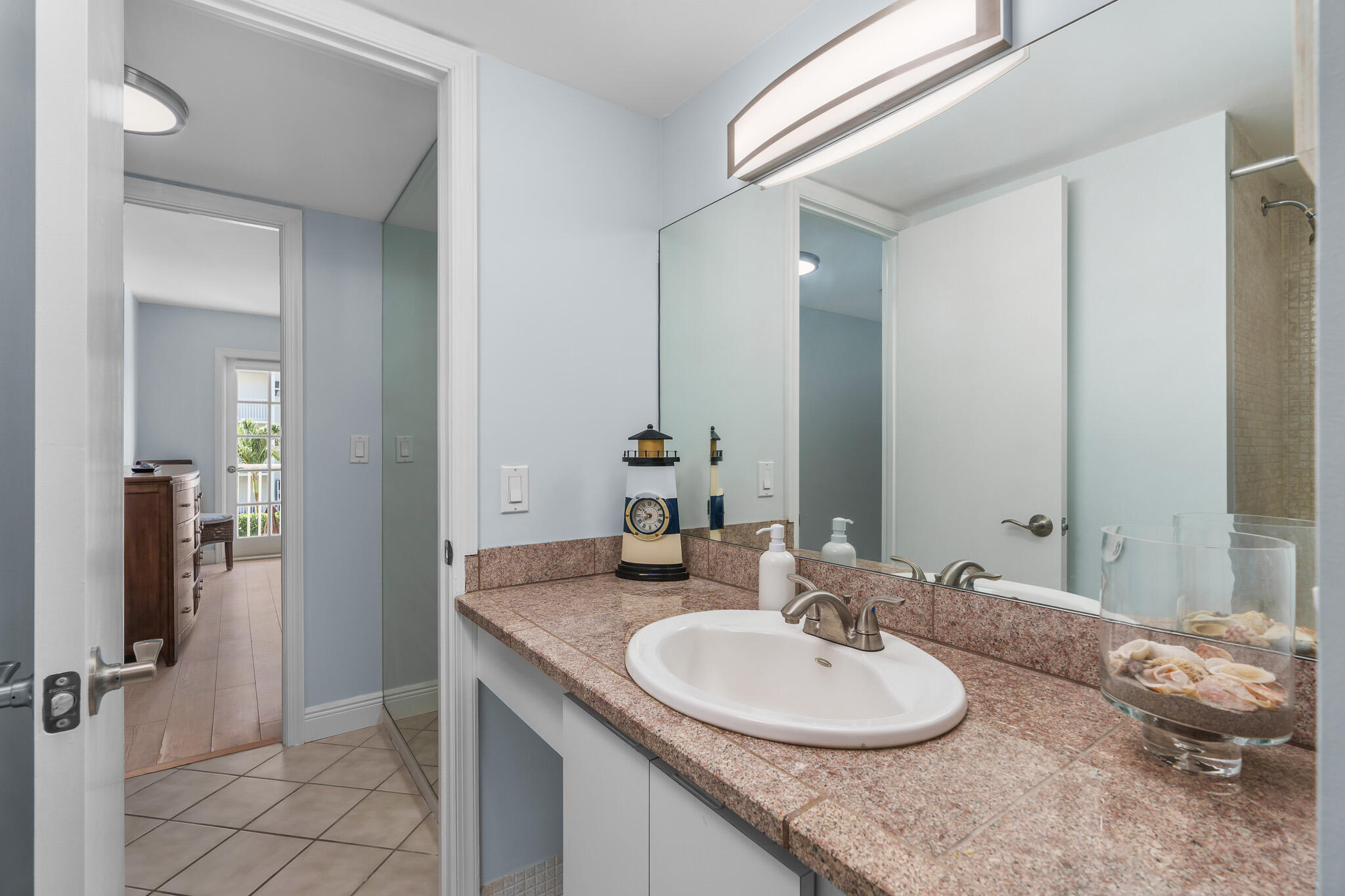 950 Ponce De Leon Road, Unit 207 Boca Raton, FL 33432 - Photo 26 of 36 a bathroom with a granite countertop sink and a mirror