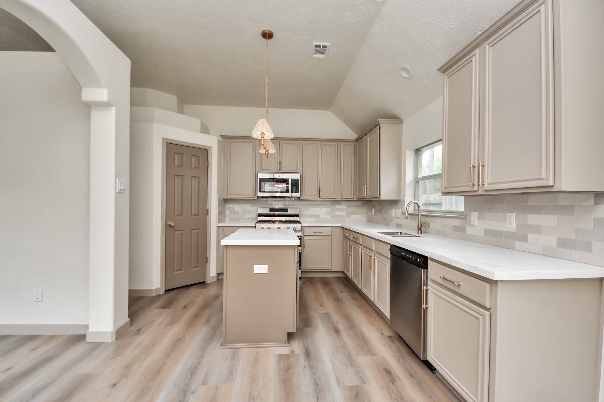 14423 Gadwall Court Houston, TX 77044 - Photo 25 of 42 a kitchen with a sink a counter top space stainless steel appliances and cabinets