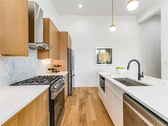 a kitchen with stainless steel appliances a sink stove and refrigerator
