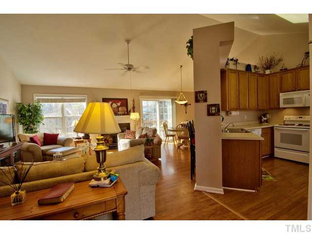 6 Bethany Place Durham, NC 27712 - Photo 1 of 12 a living room with couches a kitchen counter space and a dining table with wooden floor