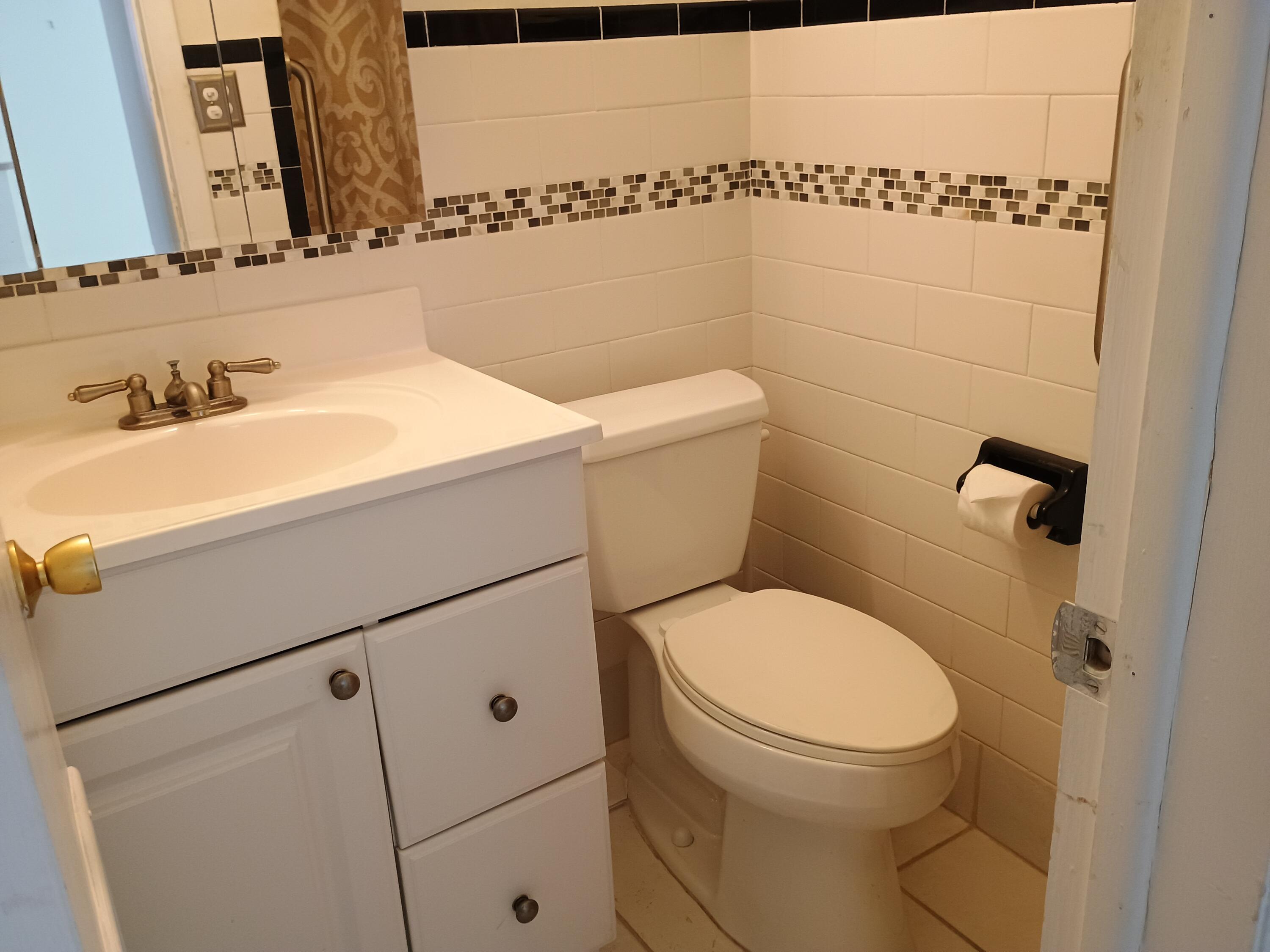 5505 North Ocean Boulevard, Unit 8110 Ocean Ridge, FL 33435 - Photo 16 of 18 a bathroom with a toilet a sink and a mirror