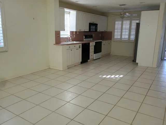 a kitchen with stainless steel appliances a sink window and cabinets