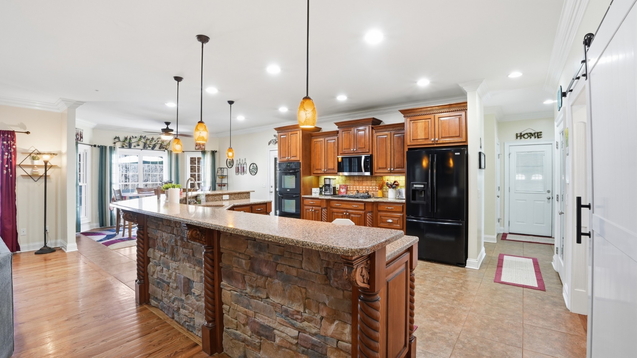 135 Vols Lane Estill Springs, TN 37330 - Photo 11 of 56 a kitchen with stainless steel appliances kitchen island granite countertop a refrigerator a oven a sink and a fireplace with wooden floor